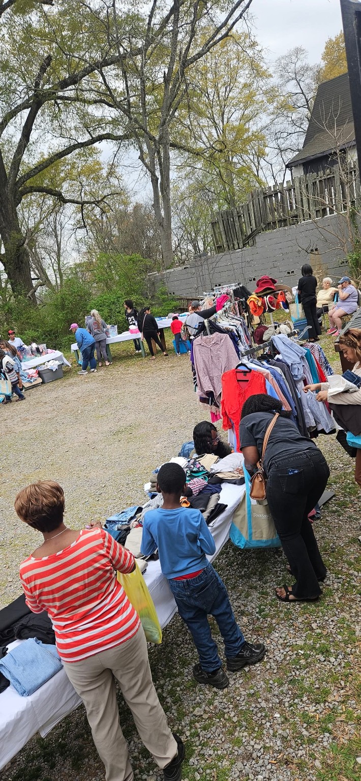 Neighbors choosing clothing from outdoor racks and tables