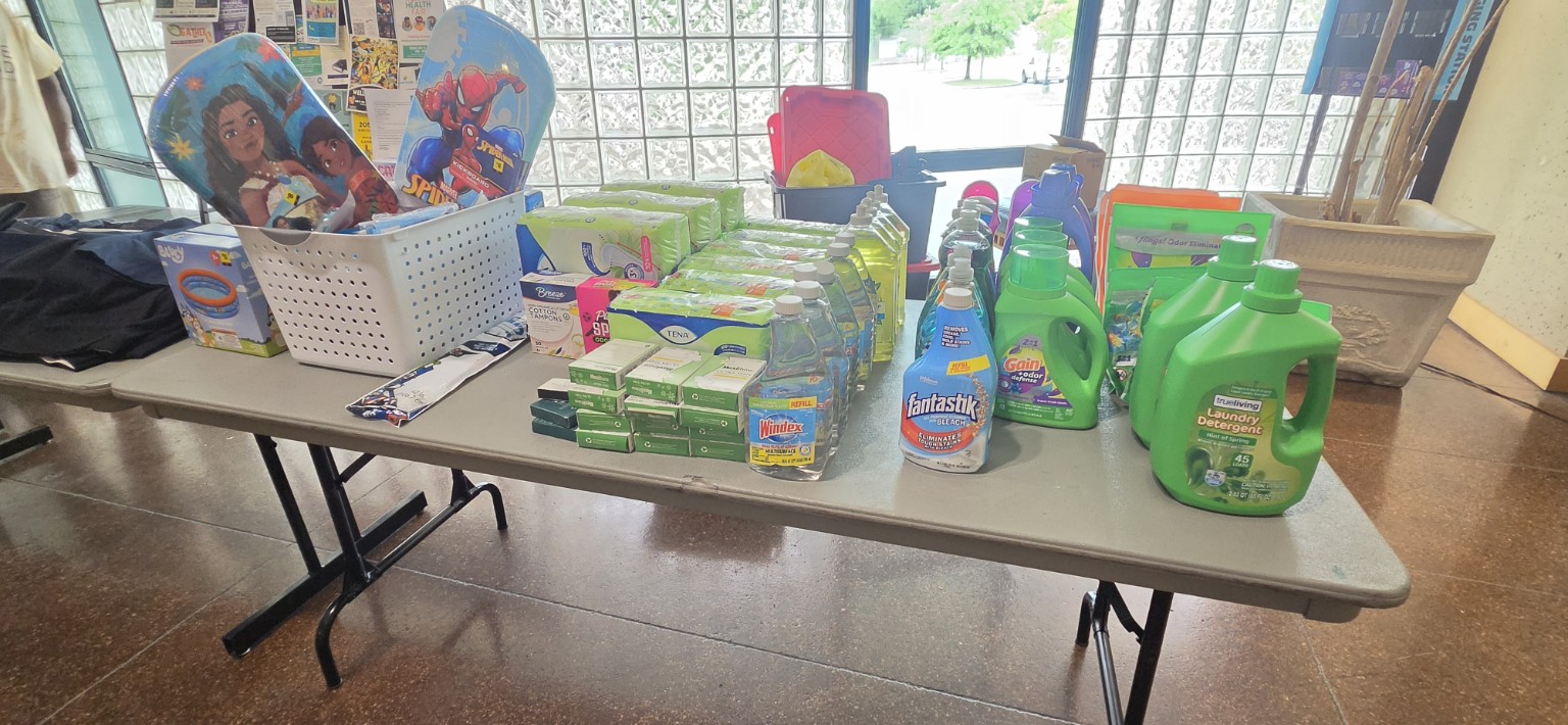 Laundry detergent, personal-care products and children’s summer items arranged at a library pop-up